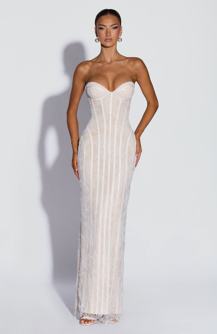 Witte kanten maxi-jurk met korsetribben en glinsterende kralen, frontaal gedragen door een model met parelkleurige oorbellen. 9