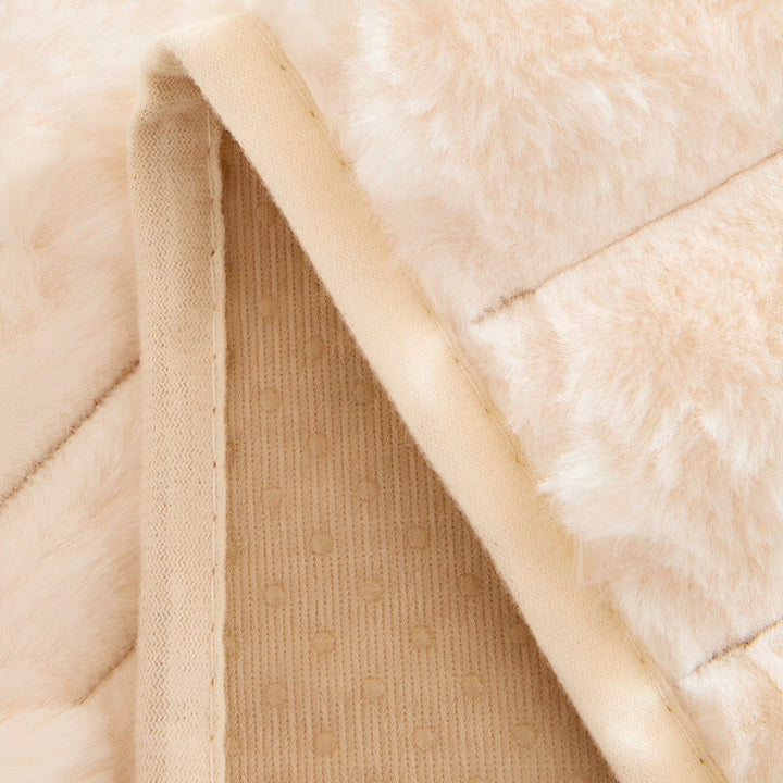 Onderkant van de hoes omgevouwen, met het gebreide beige achterlaagje met kleine antislipstippen en de gestikte rand. 6
