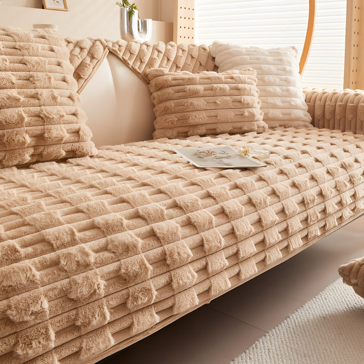 Dezelfde bankhoes in warm kamelbeige, op de bank met passende kussens en een tijdschrift erop. 9