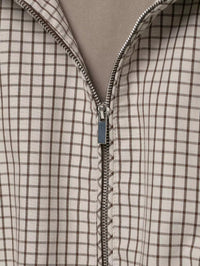 Detail van de metalen rits in het voorpand, met het fijne ruitpatroon in beige en bruin. 6