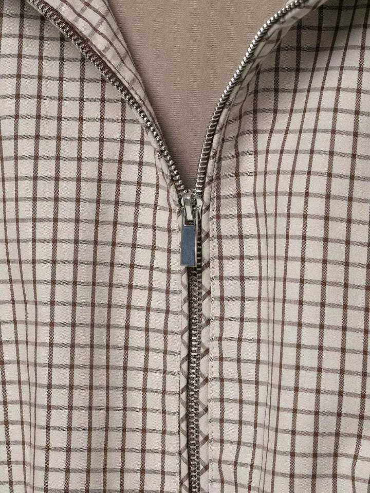 Detail van de metalen rits in het voorpand, met het fijne ruitpatroon in beige en bruin. 6