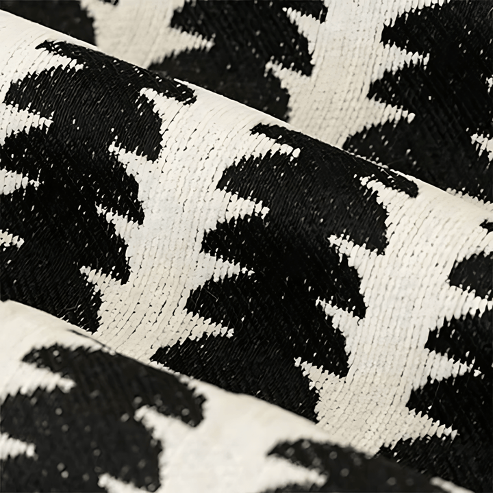 Close-up van de geweven chenille stof in zwart en crème, met het patroon en de dichte textuur van de draden zichtbaar. 2