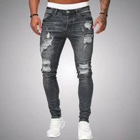 Voorkant van slim fit jeans met scheuren in grijs verweerd denim, gedragen door een model met witte sneakers. 5
