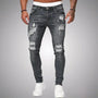 Voorkant van slim fit jeans met scheuren in grijs verweerd denim, gedragen door een model met witte sneakers. 5
