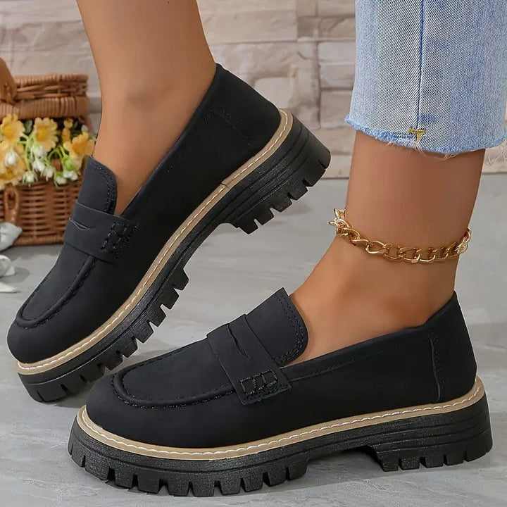 Zwarte loafers met beige rand langs de dikke zool, gedragen met gouden enkelbandje en uitgerafelde jeans. 12