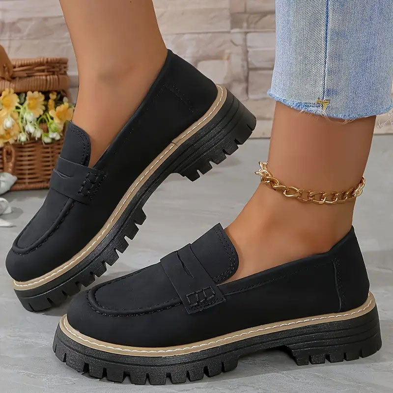 Zwarte loafers met beige rand langs de dikke zool, gedragen met gouden enkelbandje en uitgerafelde jeans. 12