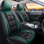 Twee voorstoelen met zwart-groene leerlook hoezen, groene hoofdsteunen en groene zijpanelen in een auto met stadsuitzicht. 13
