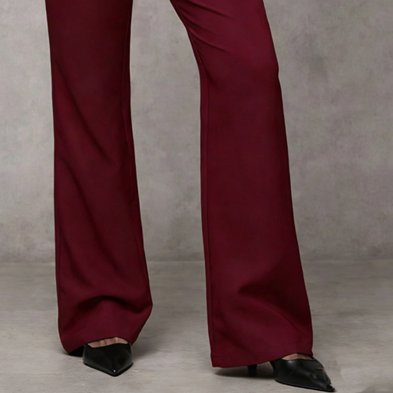 Detail van de onderkant van de bordeauxrode broek met wijd uitlopende pijpen en zwarte puntschoenen. 10