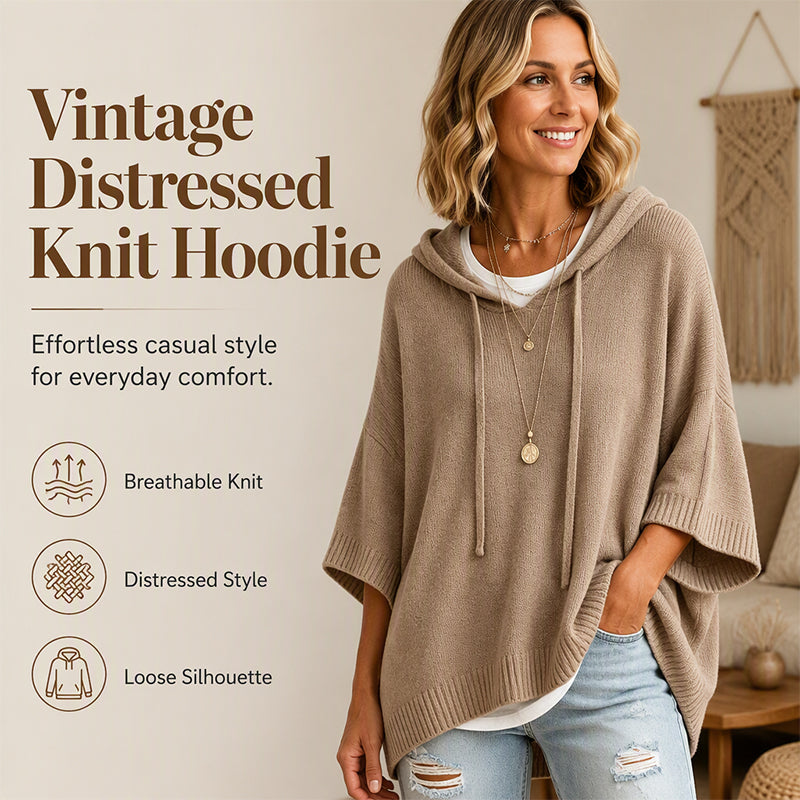Lachende vrouw draagt de beige oversized gebreide trui met capuchon en trekkoord, met kettingen en gescheurde jeans, met kenmerken in beeld. 1
