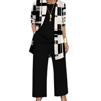 Zwart-witte set: cardigan met grafische blokkenprint, zwart shirt met ronde hals en zwarte wijde broek. 8