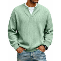 Voorkant van de wafeltop in mintgroen met neplaag, gedragen door een model met jeans en horloge. 10