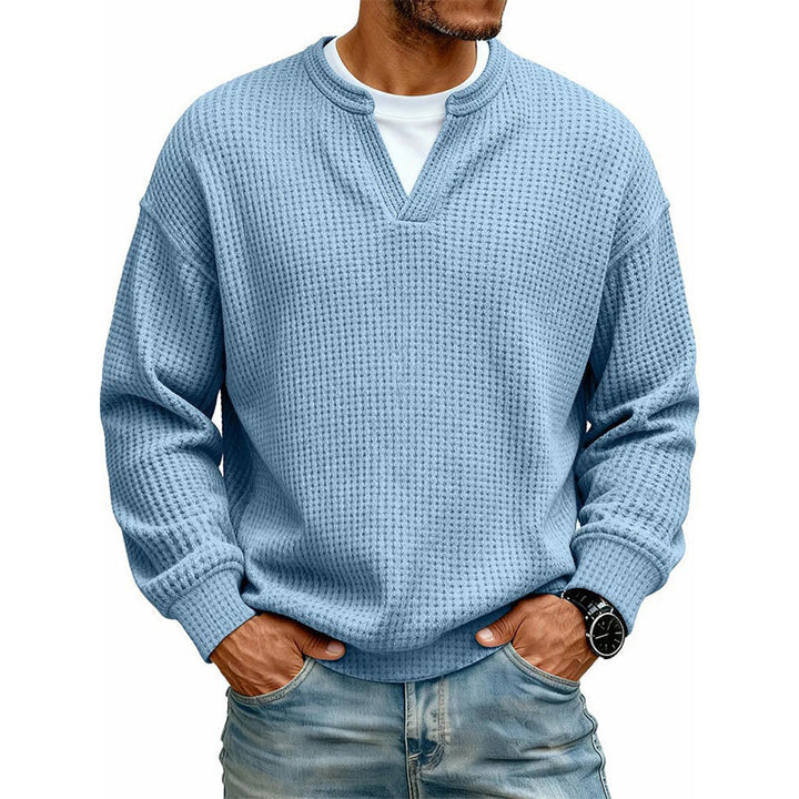 Voorkant van de wafeltop in lichtblauw met neplaag, gedragen door een model met jeans. 12