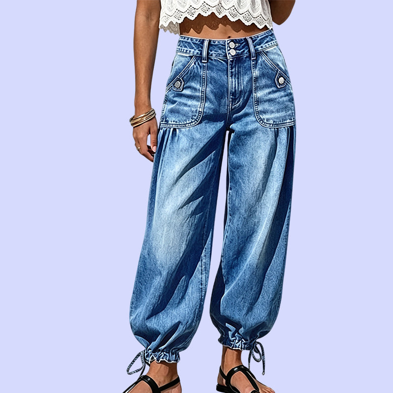 Voorkant van de blauwe barreljeans met hoge taille, dubbele knoopsluiting, opgestikte zakken en strikkoorden aan de zoom, tegen lila achtergrond. 10