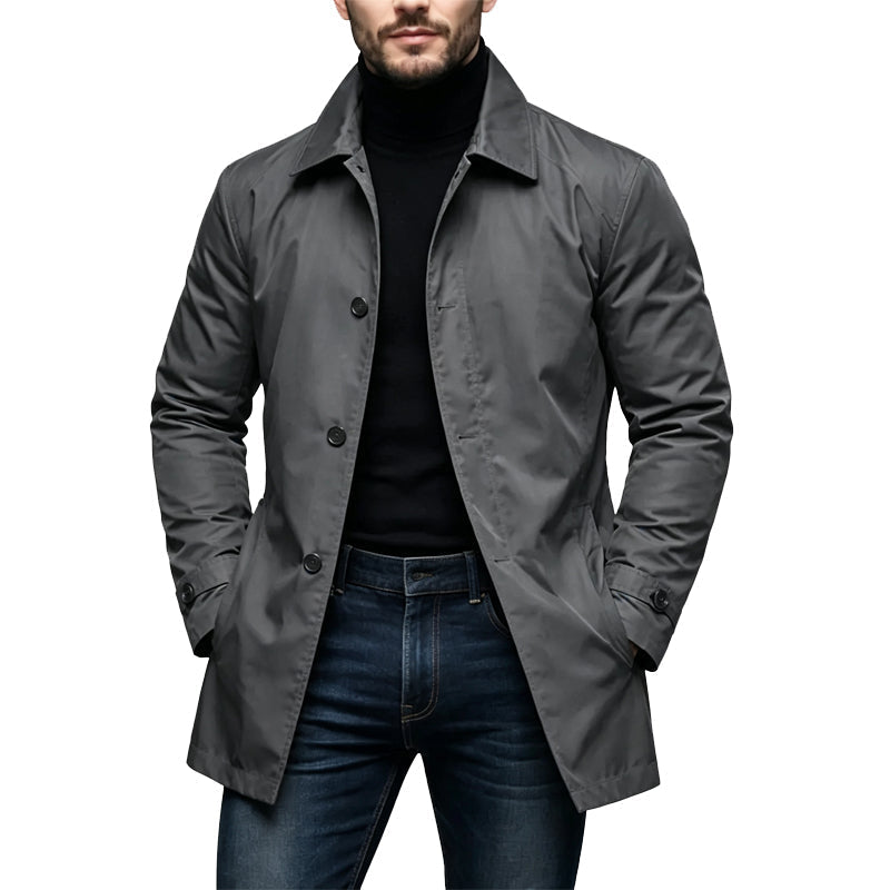 Man draagt de donkergrijze versie van de halflange jas met knopen, over een zwarte coltrui en donkere jeans. 2