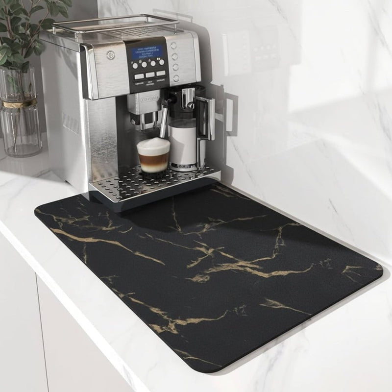 Zwarte mat met goudkleurige marmerlook-aders onder een koffiemachine op een wit marmeren aanrechtblad. 5