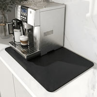 Zwarte mat met fijne leerachtige structuur onder een koffiemachine op een wit marmeren aanrecht. 9