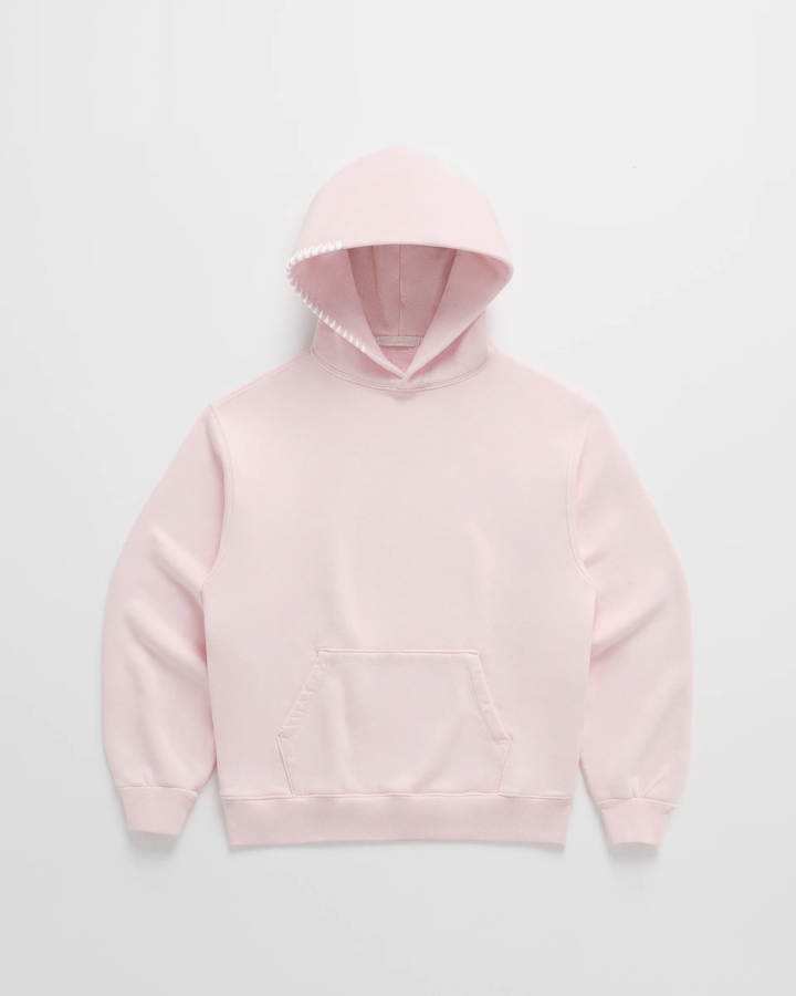Lichtroze hoodie van voren, met witte stiksels langs de capuchonrand, een buidelzak en geribbelde manchetten. 3