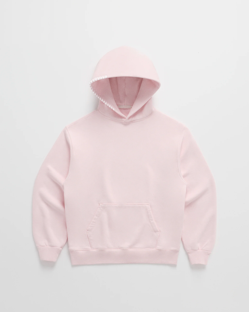 Lichtroze hoodie van voren, met witte stiksels langs de capuchonrand, een buidelzak en geribbelde manchetten. 3