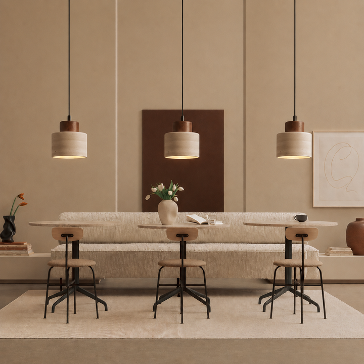 Drie hanglampen in een rij boven ronde tafels met stoelen en een bankje 3