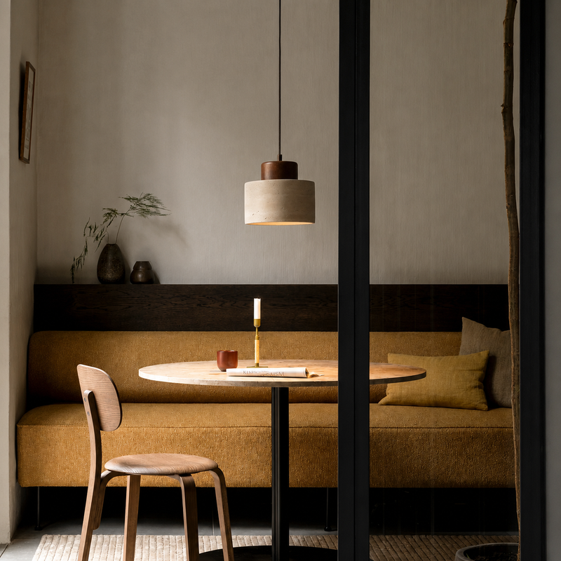 Enkele hanglamp boven een rond tafeltje met kaars, in een hoekje met gele bank 4