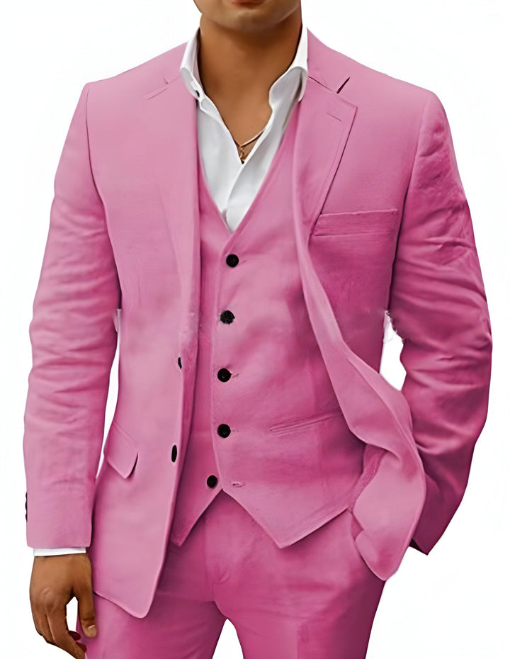 Model draagt het pak in roze met gilet, zwarte knopen en wit overhemd met open kraag. 14