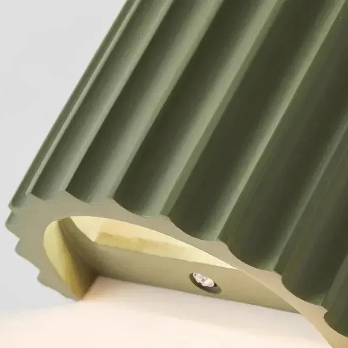 Close-up van de onderkant van een groene wandlamp met geribbeld oppervlak en een klein ledlampje 14