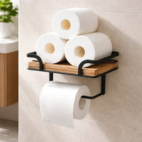 Drie extra rollen toiletpapier opgestapeld op het houten plankje van de houder, met een losse rol aan de stang eronder. 4
