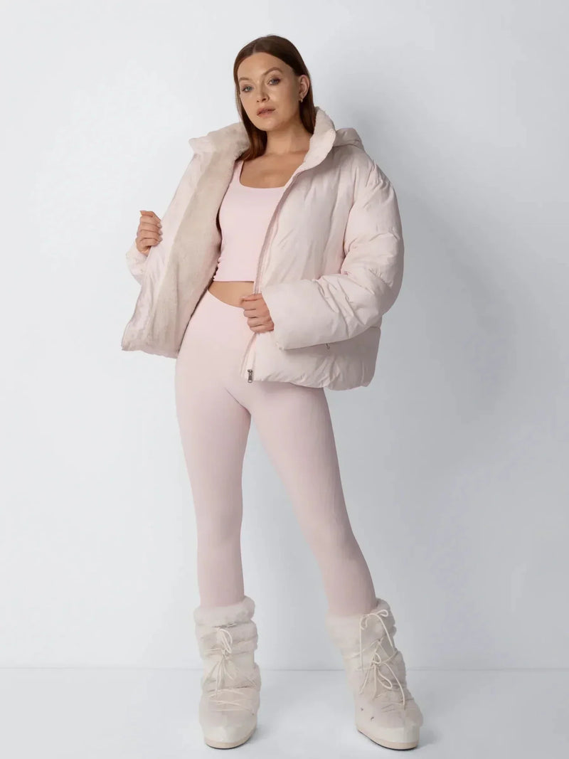 Model in roze pufferjack opent het voorpand om de zachte fleece voering te tonen, met laarzen 8