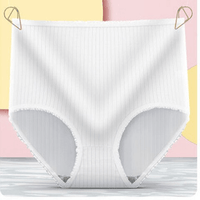 Witte geribbelde hoge slip met gerimpelde kantrand, hangend aan twee gouden clipjes voor een roze en gele achtergrond. 4