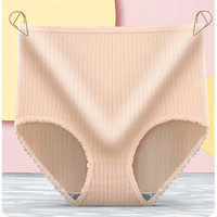 Beige geribbelde hoge slip met gerimpelde rand, hangend aan twee gouden clipjes voor een pastelkleurige achtergrond. 9