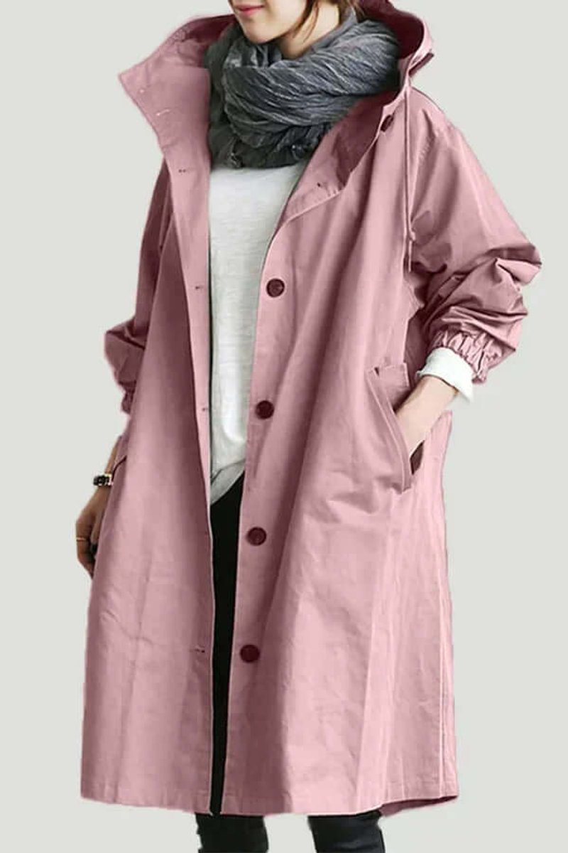 Roze lange jas met capuchon en knoopsluiting, gedragen met grijze sjaal en hand in de zak 1