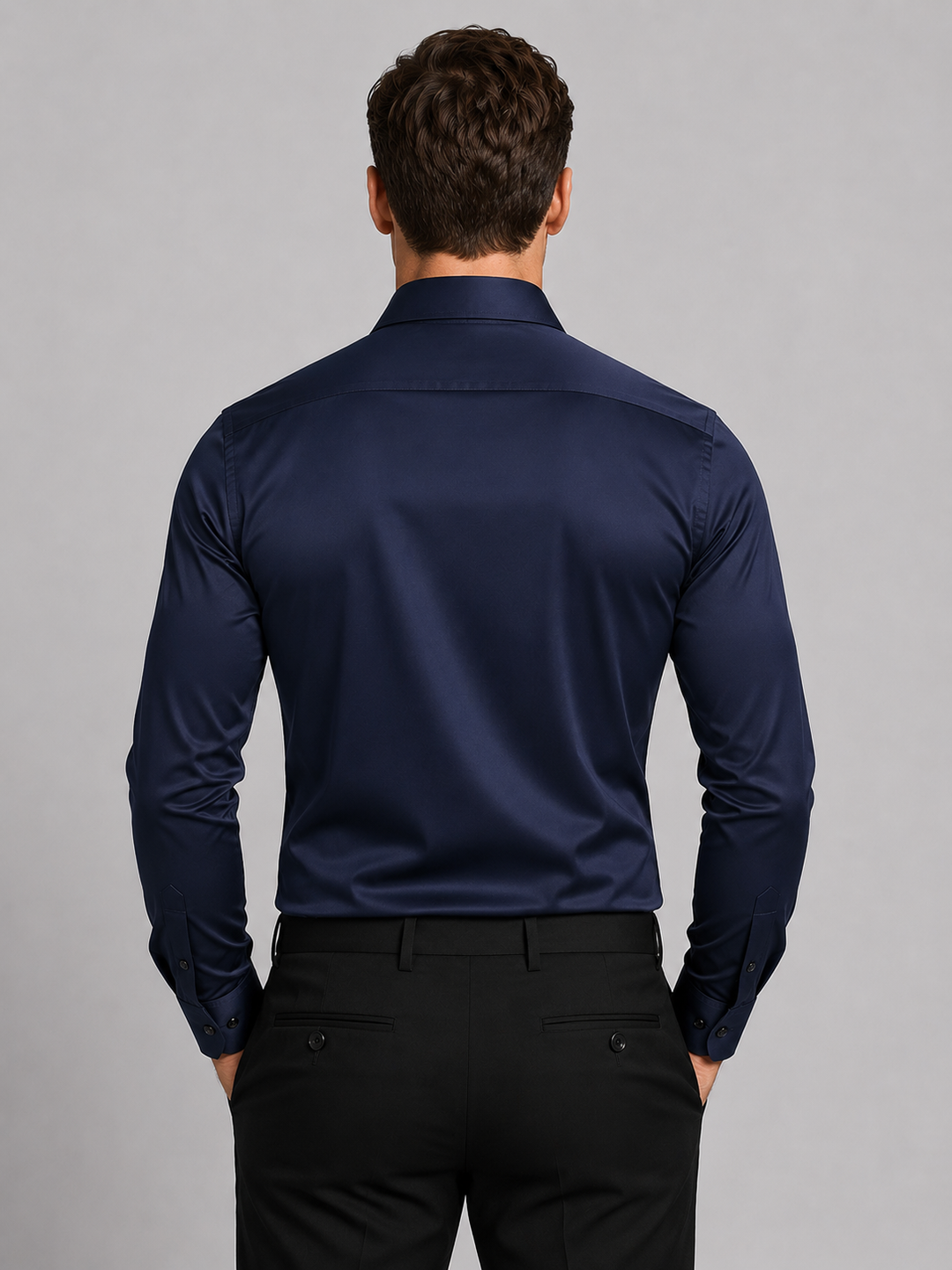 Model draagt het marineblauwe overhemd van achteren, met een gladde rug, lange mouwen met manchetknopen en een zwarte pantalon. 6