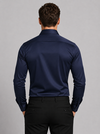 Model draagt het marineblauwe overhemd van achteren, met een gladde rug, lange mouwen met manchetknopen en een zwarte pantalon. 6
