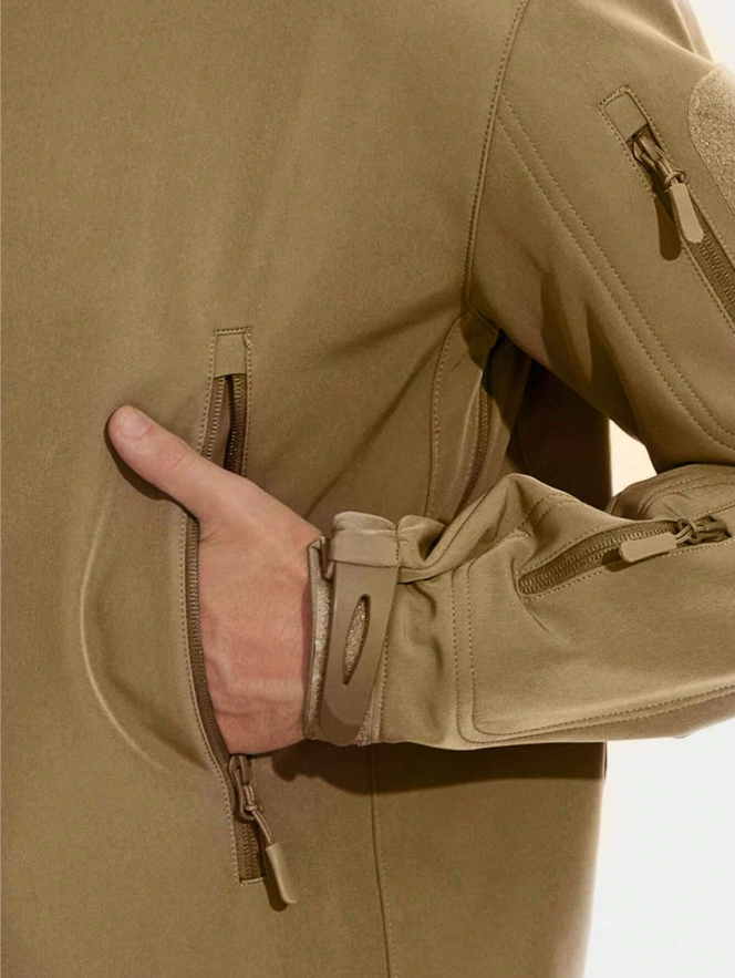 Detail van een beige jas: hand in het ritsvak, met mouwband, ritsen en naadwerk goed zichtbaar. 13