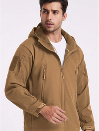 Man draagt de beige jas open over een wit shirt, waarbij de zachte capuchonvoering en het koord zichtbaar zijn. 17